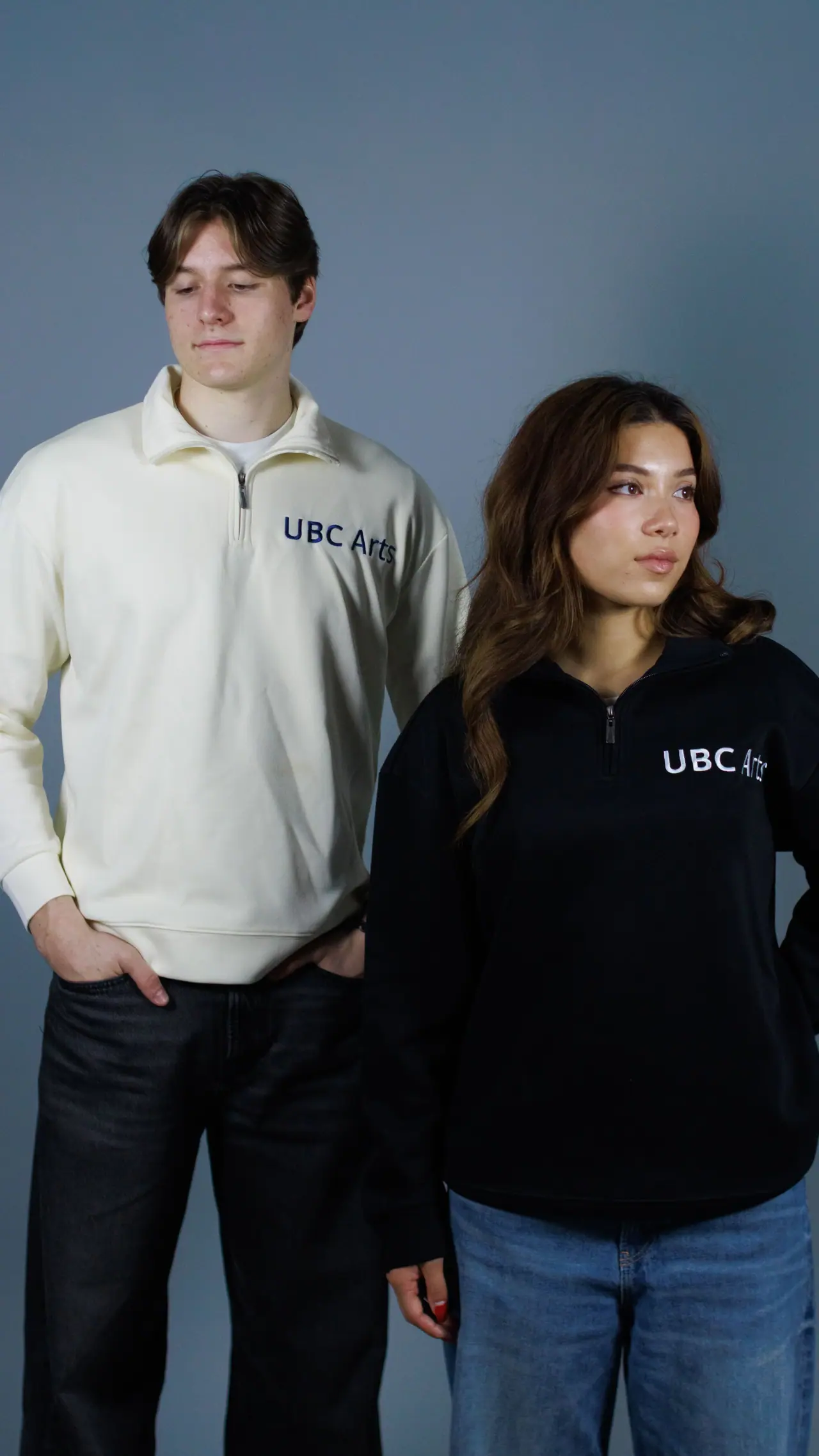 Two students in UBC Arts quarter-zips, one cream and one black